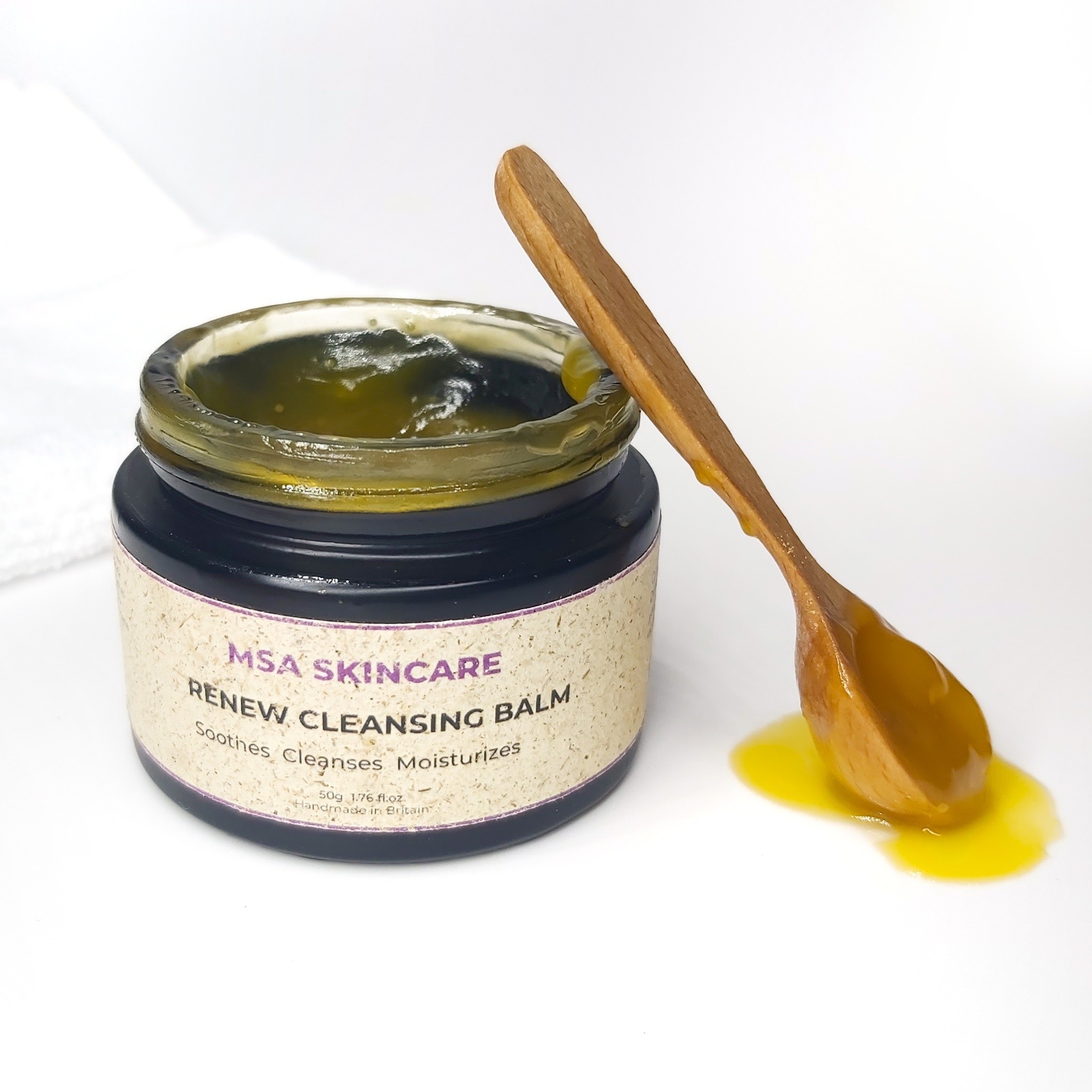 An open jar of MSA Skincare's Renew Cleansing Balm with a spoon of balm propped up against the jar. Natural SKincare review by Beauty Folio.